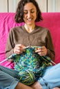 A woman knits from thick yarn