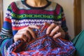 A woman knits from thick yarn, hands of a knitter