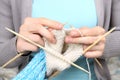 Woman knitting blue socks closeup