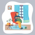 Woman knitting sitting at chair near window, hobby and leisure, quarantine isolation at home