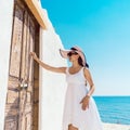 Woman knocking on the door of a beach home in Greece
