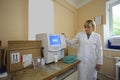 Woman lab assistant in white coat working with the hematology analyzer. Laboratory of a hospital. Kyiv, Ukraine Royalty Free Stock Photo