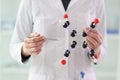 Woman in lab coat demonstrates molecule model in hands Royalty Free Stock Photo