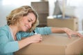 woman labelling cardboard box for moving house Royalty Free Stock Photo