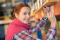 Woman labelling shelf under pallet in warehouse