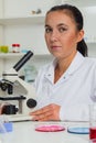 Woman in a laboratory microscope with microscope slide in hand Royalty Free Stock Photo