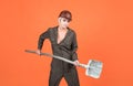 woman laborer in protective helmet and boilersuit hold shovel on orange background, workers day Royalty Free Stock Photo