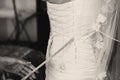 Woman lace up a corset on the delicate bride's waist