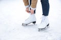Woman lacing figure skate on ice rink, closeup Royalty Free Stock Photo