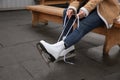 Woman lacing figure skate while sitting on bench, closeup Royalty Free Stock Photo