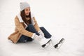 Woman lacing figure skate while sitting on ice rink Royalty Free Stock Photo