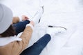 Woman lacing figure skate while sitting on ice rink, above view Royalty Free Stock Photo