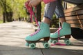 Woman lacing roller skates while sitting on bench outdoors, closeup Royalty Free Stock Photo