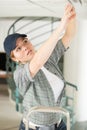 Woman on ladder fitting light bulb in new house