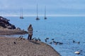 Woman by the lake feeding ducks with a child. Ascona, Lago Maggiore, Switzerland Royalty Free Stock Photo