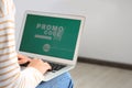 Woman with laptop activating promo code while doing online shopping indoors, closeup. Space for text