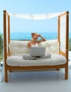 Woman with laptop on canopied seat Royalty Free Stock Photo