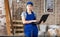 Woman with laptop on indoor construction site