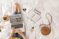 Woman and laptop with open cooking blog on bed