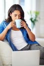 Woman, laptop and relax on sofa with coffee for morning routine, working online or read social media communications on Royalty Free Stock Photo