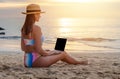 Woman with laptop on sea beach