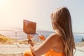 Woman laptop sea. Working remotely on seashore. Happy successful woman female freelancer working on laptop by the sea at Royalty Free Stock Photo