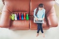 Woman with laptop shopping online with debit card on sofa in home