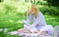 Woman with laptop sit on rug grass meadow. Girl with notepad write note. Business lady freelance work outdoors