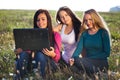 Woman with a laptop sitting in the field o