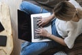 Woman with a laptop sitting on a sofa. Study and work online, freelance. Self employed woman, girl working with her