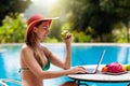 Woman with laptop at swimming pool. Remote work