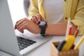 Woman with laptop using smartwatch at white table, closeup Royalty Free Stock Photo