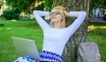 Woman with laptop works outdoor, park background. Taking advantages of free wi fi. Girl sit grass lean tree trunk with Royalty Free Stock Photo