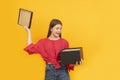 Woman with large black box. Surprised happy young girl holds an open gift. Bright yellow background