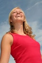 Woman laughing against blue sky Royalty Free Stock Photo