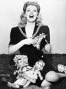 Woman laughing and cutting out paper dolls faces Royalty Free Stock Photo