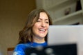 Woman laughing to herself as she reads media on her laptop computer Royalty Free Stock Photo