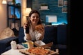 Woman laughing watching television holding lager beer bottle and takeaway fast food tasty hamburger Royalty Free Stock Photo