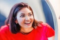 Woman laughs and looks at the reflection in a distorted mirror room Royalty Free Stock Photo