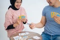 Woman laughs when male friends take one card