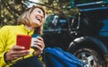 Woman laughter showing teeth calling on mobile phone summer forest while traveling auto. Happiness tourist with smile holding cell