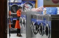 Woman in a laundromat waiting for her clothes. Royalty Free Stock Photo