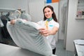 Woman laundry administrator holding clothe covered in plastic bag