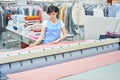 Woman Laundry worker pats the linen on the automatic machine Royalty Free Stock Photo