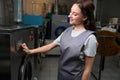 Woman laundry worker is programming washing machine Royalty Free Stock Photo