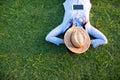 Woman lay down sleep on green grass meadow garden summer sunshine day happy time outside. Hipster Freelance work on laptop use hat Royalty Free Stock Photo