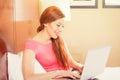 Woman laying in bed relaxing using working on her laptop computer Royalty Free Stock Photo