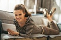 Woman laying on couch and using tablet pc in loft Royalty Free Stock Photo