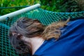 Woman laying down on a hammock and her face covered by her hairs Royalty Free Stock Photo