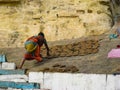 Woman is laying dung cakes for drying and obtaining fuel